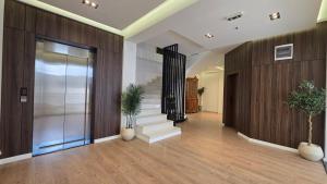 eine Bürolobby mit Treppe und gläsernem Aufzug in der Unterkunft Hotel Velaris in Struga