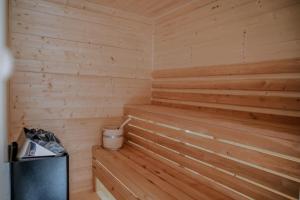 a wooden sauna with a trash can in it at Domek Za Dworem in Witów