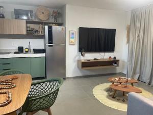 a kitchen with a refrigerator and a table with chairs at Villa Maui - Milagres in Passo de Camarajibe