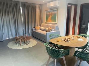 a living room with a couch and a table and chairs at Villa Maui - Milagres in Passo de Camarajibe +39 photos