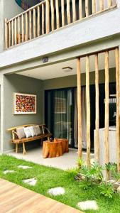 a patio with a couch and a table under a staircase at Villa Maui - Milagres in Passo de Camarajibe