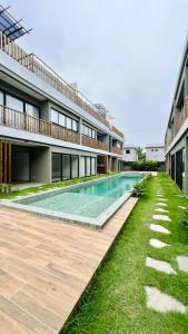 a swimming pool in front of a building at Villa Maui - Milagres in Passo de Camarajibe