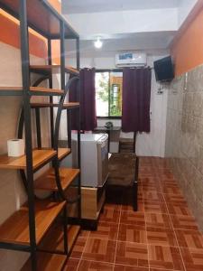 a room with bunk beds in a room with a kitchen at Regina Hotel in Balasan