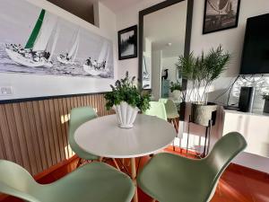 a dining room with a white table and chairs at Santiago Oceanfront Living in Sesimbra