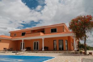 an orange house with a pool in front of it at Quinta da Shambhala in Soriço