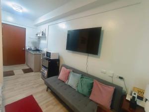 a living room with a couch and a flat screen tv at Hailey's Place in Bacolod