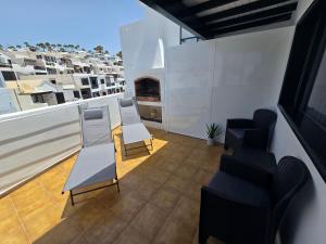 a balcony with chairs and a fireplace on a building at Casa Memela 6 in Tías