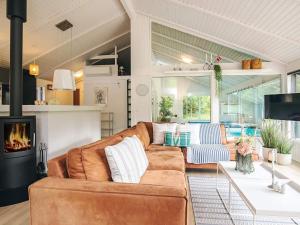 a living room with a couch and a fireplace at 5 star holiday home in Bindslev in Bindslev