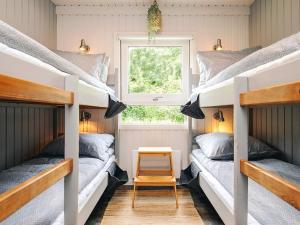 two bunk beds in a room with a window at 5 star holiday home in Bindslev in Bindslev +29 photos