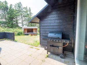 a grill outside of a house next to a yard at Luxury Retreat in Vorupor in Snedsted