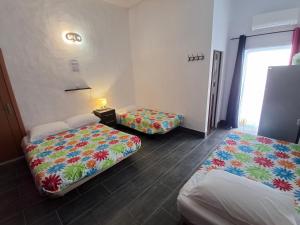 a room with two beds with colorful sheets at vila gira odeceixe in Odeceixe