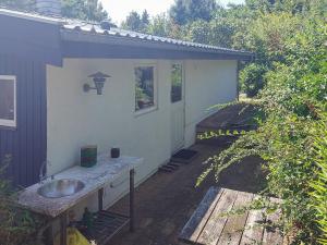 a house with a sink on a patio at 4 star holiday home in Hundested in Hundested
