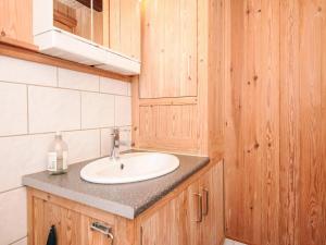 a bathroom with a white sink and wooden cabinets at 8 person holiday home in Hovborg-By Traum in Hovborg +41 photos