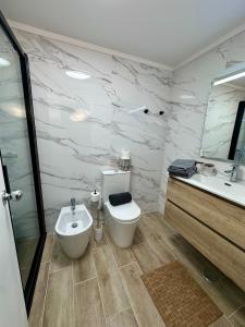 a bathroom with a toilet and a sink at Santiago Oceanfront Living in Sesimbra +26 photos