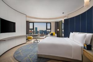 a hotel room with a large bed and a television at voco Xian ETDZ by IHG in Xi'an +200 photos