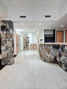 an empty lobby with a stone wall at Village Garden Apart Hotel in Buenos Aires