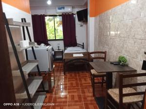a room with a room with a bed and a table at Regina Hotel in Balasan