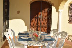ミアミ・プラトーヤにあるVilla Los Inkasの白い椅子と青いテーブルクロス