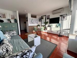a living room with a couch and a tv at Santiago Oceanfront Living in Sesimbra