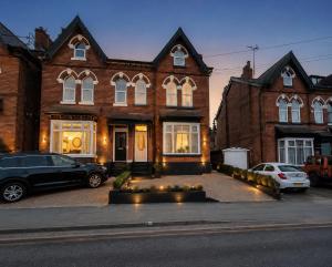 a brick house with cars parked in front of it at Spacious Large Group House Near NEC and Airport in Birmingham