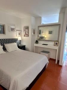 a bedroom with a white bed and a desk at Santiago Oceanfront Living in Sesimbra