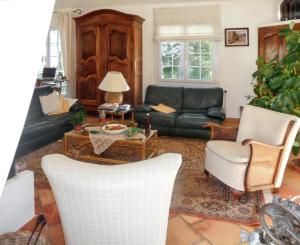a living room with a black leather couch and chairs at Villa élégante à Céreste avec piscine privée et jacuzzi in Céreste