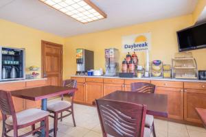 a restaurant with a table and chairs and a counter at Days Inn by Wyndham Columbus Fairgrounds in Columbus