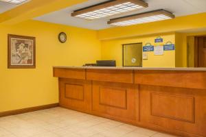 a waiting room with yellow walls and a counter at Days Inn by Wyndham Columbus Fairgrounds in Columbus