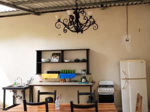 a kitchen with a refrigerator and a chandelier at The Frontside Surf House in Tamarindo