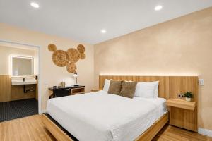 a bedroom with a large white bed and a desk at The Beverly House by AGA - Beverly Hills in Los Angeles
