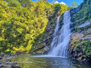 a waterfall in the middle of a river at Pousada Caiçara Zen in Paraty +29 photos