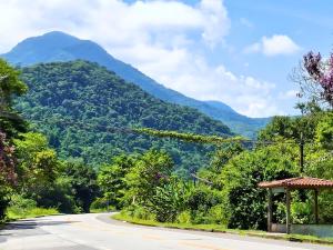 an empty road with a mountain in the background at Pousada Caiçara Zen in Paraty