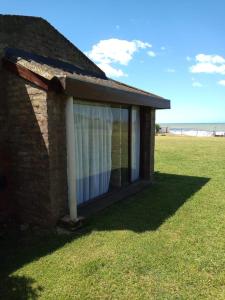 a building with a window with the beach in the background at Complejo Casa Clara in Santa Clara del Mar