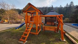 a wooden playground with a ladder and a house at Penzion Adélka Janské Lázně in Janske Lazne