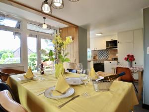a dining room table with a yellow table cloth at Sous les Hetres in Robertville
