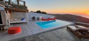 a villa with a swimming pool and a sunset at 3 SENSES villa in Dhriopís