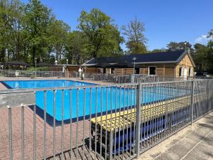 a swimming pool with a fence around it at Villa Fox in IJhorst