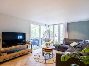 a living room with a couch and a tv at Villa Fox in IJhorst