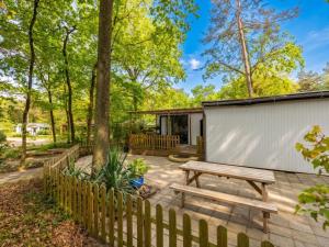 a patio with a wooden bench and a fence at Villa Fox in IJhorst