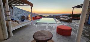 a villa with a swimming pool with a table and chairs at 3 SENSES villa in Dhriopís