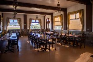 a dining room with tables and chairs and windows at Villas Persas by Jardin de Persia in Valle de Guadalupe