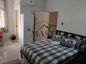 a bedroom with a bed with a blue and white checkered blanket at The MAST Stay "for islam people only" in Tampin