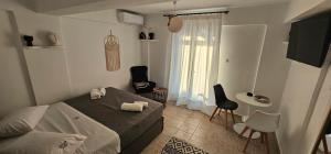 a bedroom with a bed and two chairs and a window at 3 SENSES villa in Dhriopís