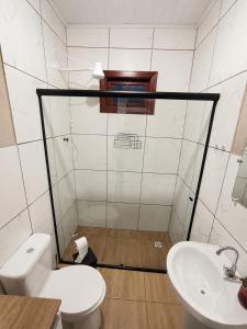 a bathroom with a toilet and a sink at Pousada Vale das Flores in Charqueadas