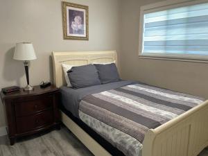 a bedroom with a bed with a nightstand and a window at Central Vally Private House in Abbotsford