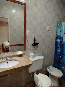 a bathroom with a sink and a toilet and a mirror at Hotel Nerja in San Juan