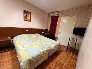 a bedroom with a bed and a desk and a chair at Hotel Nerja in San Juan