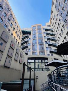 a tall building with stairs and an umbrella in front of it at iNtsika Boutique in Johannesburg