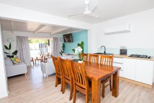 a kitchen and dining room with a wooden table and chairs at Konoha Central 9BR, 3 Pools, Sleeps 24 in Avarua