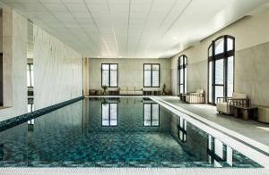 an empty pool in a large building with windows at Crowne Plaza Paris Marne-la-Vallée in Magny-le-Hongre